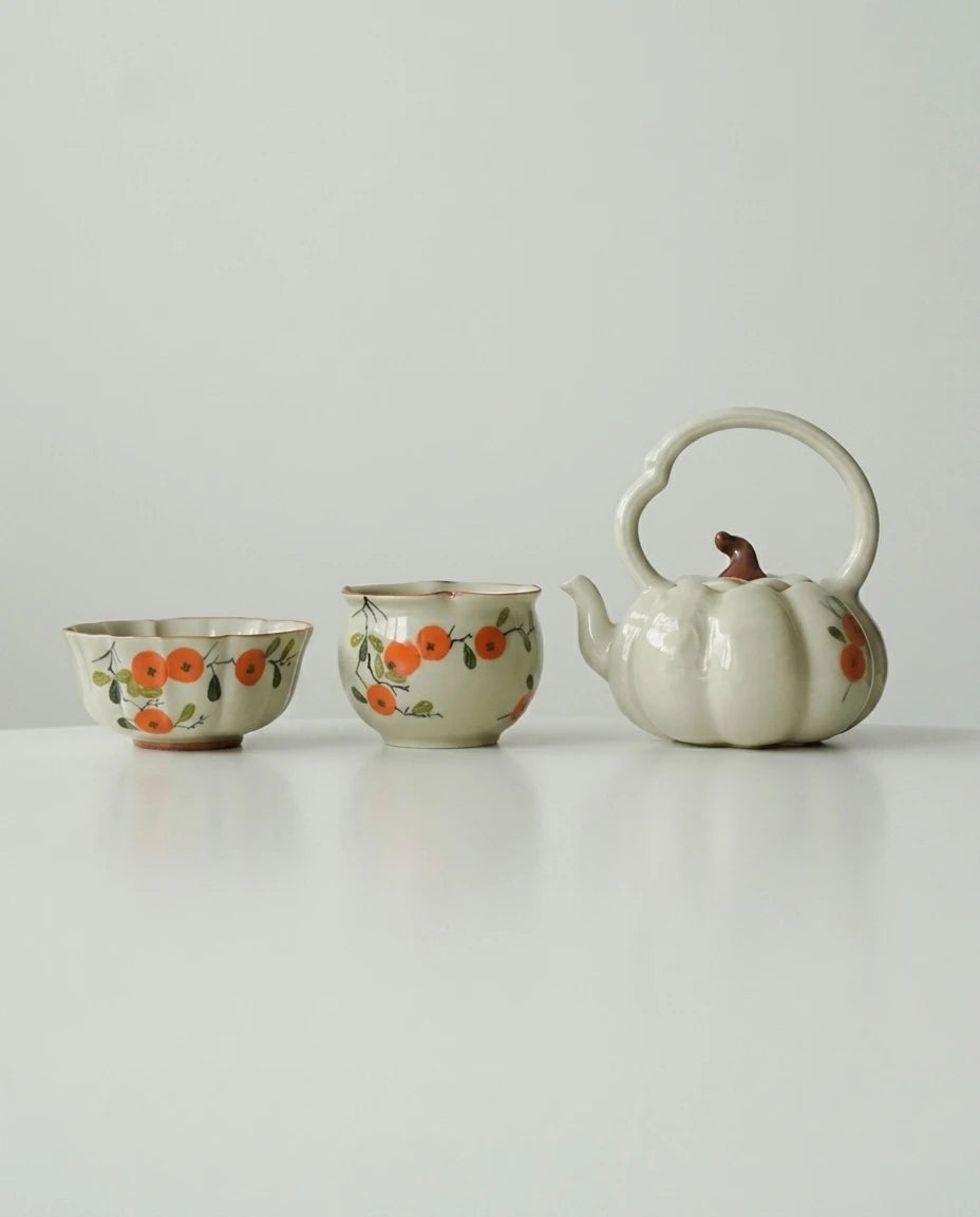 3-piece set flatlay: tea cup, fair cup and pumpkin lifting teapot