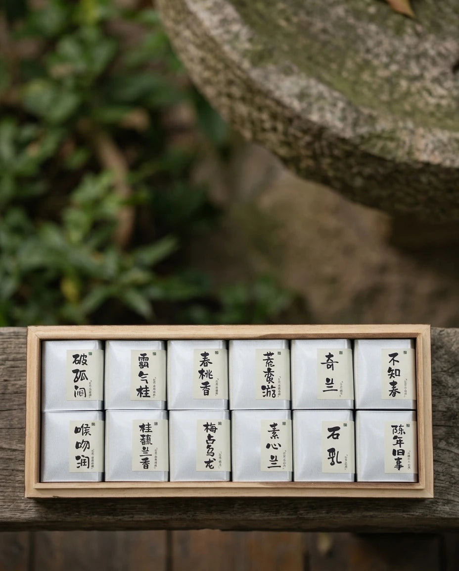 Twelve Realms of Wuyi Rock Oolong wooden gift box with 12 individual tea pouches, displayed on natural wood table