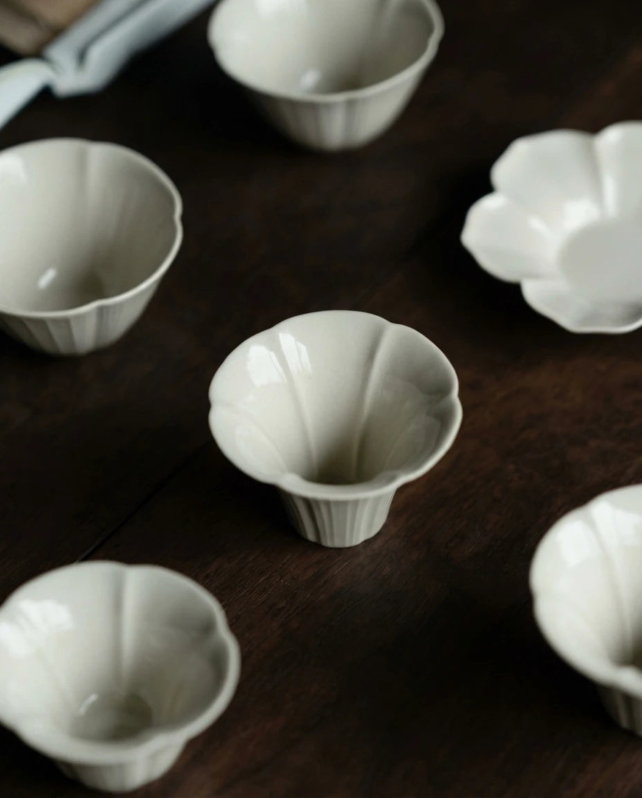 Ash Glaze Sunflower Tea Cup: Multiple cups arranged on a dark wood table