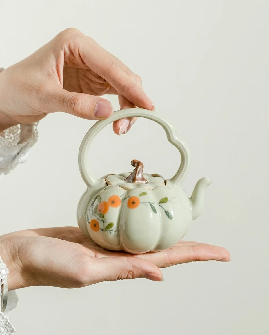 Hand-Painted Persimmon Pumpkin Teapot held in hand - hero shot